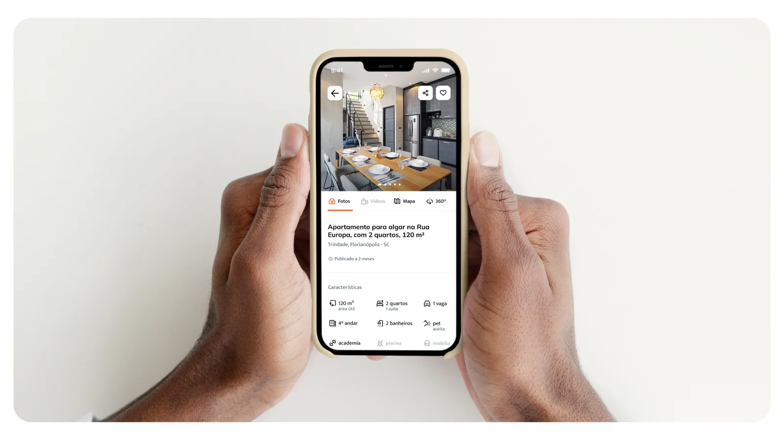 Mockup do Homekey com a tela de detalhe do imóvel num celular segurado com as duas mãos